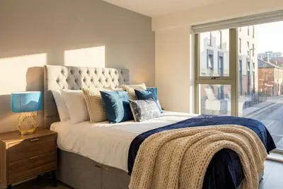 a bedroom with a bed with pillows and a window at Contemporary 1BED Apartment in Liverpool w Balcony in Liverpool