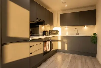 a kitchen with black cabinets and a sink at Contemporary 1BED Apartment in Liverpool w Balcony in Liverpool