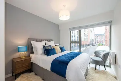 a bedroom with a bed and a large window at Contemporary 1BED Apartment in Liverpool w Balcony in Liverpool