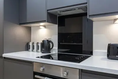 a kitchen with a stove top oven next to a counter at Contemporary 1BED Apartment in Liverpool w Balcony in Liverpool