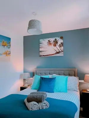 a blue bedroom with a bed with blue walls at Modern 3-bed house with parking - Chorley Near M61 in Heapey