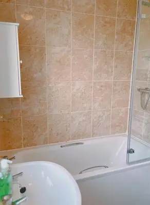 a bathroom with a tub and a sink at Modern 3-bed house with parking - Chorley Near M61 in Heapey
