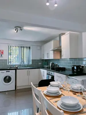 a kitchen with a table with plates and wine glasses at Modern 3-bed house with parking - Chorley Near M61 in Heapey