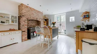 a kitchen with a brick fireplace and a stove at Georgian Residence - 4BR Modern Living, Sleeps 8! in Liverpool