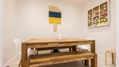 a wooden table in a room with chairs and paintings at Georgian Residence - 4BR Modern Living, Sleeps 8! in Liverpool