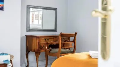 a wooden desk with a mirror and a chair at Georgian Residence - 4BR Modern Living, Sleeps 8! in Liverpool