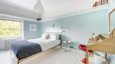 a bedroom with blue walls and a bed and a desk at Georgian Residence - 4BR Modern Living, Sleeps 8! in Liverpool