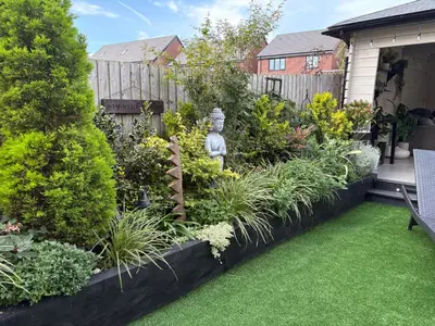 a garden with plants and a statue in a yard at Modern Detached House with multiple parking and large garden next to Anfield Stadium in Liverpool