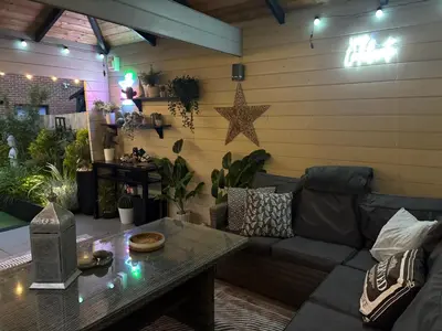 a living room with a couch and a table at Modern Detached House with multiple parking and large garden next to Anfield Stadium in Liverpool
