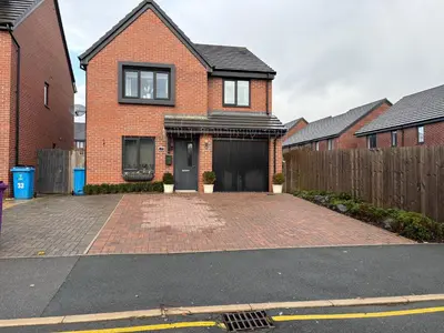a brick house with a driveway in front of it at Modern Detached House with multiple parking and large garden next to Anfield Stadium in Liverpool