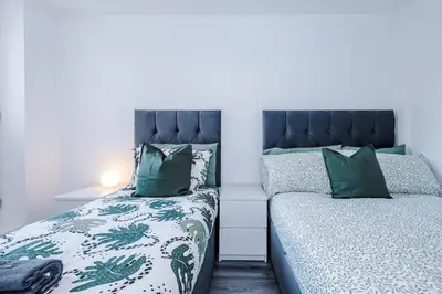 a bedroom with two beds with green and white sheets at Walkable distance to LFC & EFC Stadiums in Liverpool