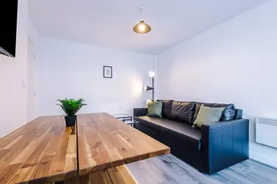 a living room with a couch and a wooden table at Walkable distance to LFC & EFC Stadiums in Liverpool