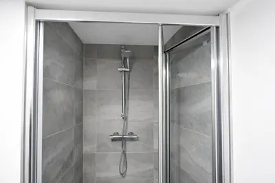 a shower with a glass door in a bathroom at The Big Home - 8 bedrooms, 11 Beds, Long stays welcome, Free parking in Wallasey