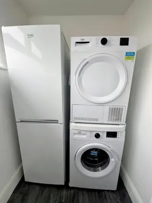 a washer and dryer next to a refrigerator at The Big Home - 8 bedrooms, 11 Beds, Long stays welcome, Free parking in Wallasey
