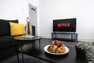 a living room with a table with a plate of cookies at The Big Home - 8 bedrooms, 11 Beds, Long stays welcome, Free parking in Wallasey