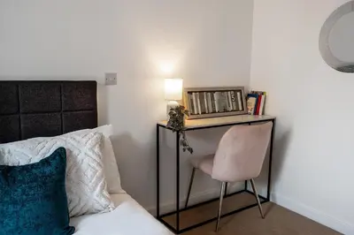 a bedroom with a desk and a chair next to a bed at Modern Downtown Gem- Brand New Apartments on Cannon St in Preston