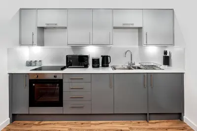 a white kitchen with a sink and a microwave at Modern Downtown Gem- Brand New Apartments on Cannon St in Preston