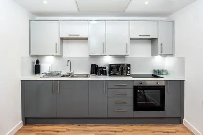 a kitchen with stainless steel appliances and white cabinets at Modern Downtown Gem- Brand New Apartments on Cannon St in Preston