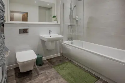 a bathroom with a sink and a tub and a toilet at Modern Downtown Gem- Brand New Apartments on Cannon St in Preston
