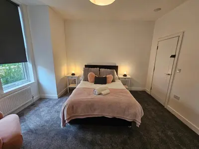 a bedroom with a large bed with two lamps at Kings Central 3 Bedroom, free parking & Wifi, dog friendly in Southport