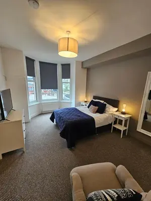 a bedroom with a bed and a couch at Kings Central 3 Bedroom, free parking & Wifi, dog friendly in Southport