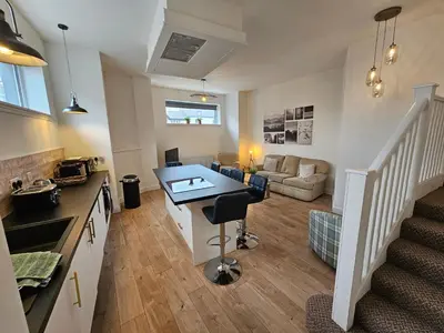 a kitchen and living room with a table and a couch at Kings Central 3 Bedroom, free parking & Wifi, dog friendly in Southport