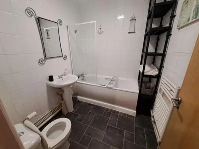 a bathroom with a toilet and a sink and a tub at City-center Flat Sleeps 4 with Balcony in Liverpool