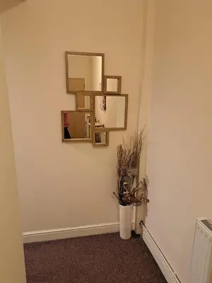 a hallway with a mirror and a plant on a wall at City-center Flat Sleeps 4 with Balcony in Liverpool