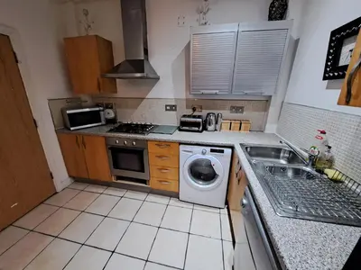 a kitchen with a washing machine and a sink at City-center Flat Sleeps 4 with Balcony in Liverpool