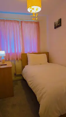 a bedroom with a bed and a desk and a window at Modern luxury 3-bedroom guesthouse in Wigan in Wigan