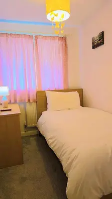 a bedroom with a bed and a desk and a window at Modern luxury 3-bedroom guesthouse in Wigan in Wigan