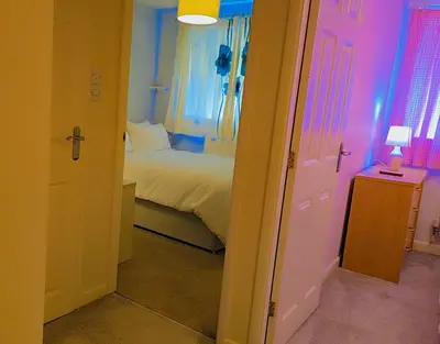 a bedroom with a bed and a room with a door at Modern luxury 3-bedroom guesthouse in Wigan in Wigan