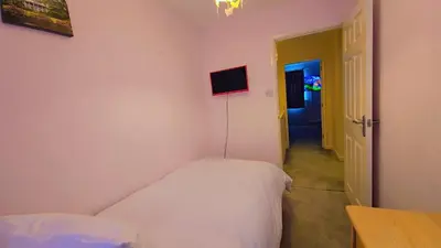 a small bedroom with a bed and a hallway at Modern luxury 3-bedroom guesthouse in Wigan in Wigan