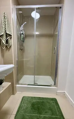 a bathroom with a shower with a green rug at Stylish City Centre Stay - 4 mins to station - Fast Wifi - Near Stadiums in Liverpool