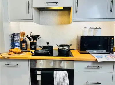 a kitchen counter with a stove and a microwave at The Anfield Snug Terraced, 3 Bedroom Home with Ensuite & Free On-Street Parking in Liverpool