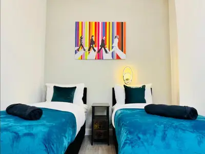 two beds sitting next to each other in a room at The Anfield Snug Terraced, 3 Bedroom Home with Ensuite & Free On-Street Parking in Liverpool