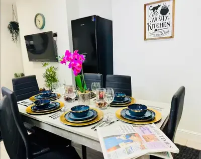 a dining room table with blue and yellow dishes on it at The Anfield Snug Terraced, 3 Bedroom Home with Ensuite & Free On-Street Parking in Liverpool