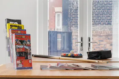 a table with a book and a pile of paper at Steven Gerrard Anfield House 6 bedroom house in Liverpool
