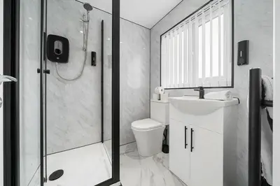 a bathroom with a shower and a toilet and a sink at Steven Gerrard Anfield House 6 bedroom house in Liverpool
