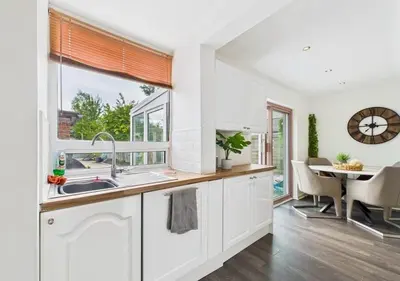 a kitchen with a sink and a dining table at Kendal By The Coast - Cosy home in great location in Blackpool