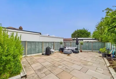 a patio with couches and a fence in a backyard at Kendal By The Coast - Cosy home in great location in Blackpool