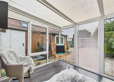 a living room with large windows and a tv at Kendal By The Coast - Cosy home in great location in Blackpool