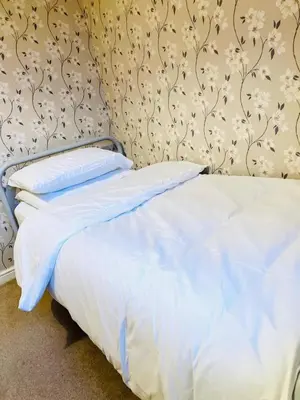 a bed with white sheets and pillows in a bedroom at Two bedroom home in quite culdisac over looking hospital in Blackburn