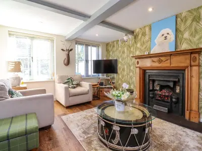 a living room with a fireplace and a couch at Gardener's Cottage in Lytham St Annes