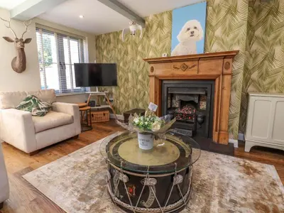 a living room with a coffee table and a fireplace at Gardener's Cottage in Lytham St Annes