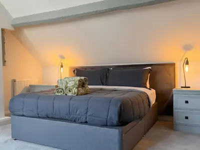 a large bed in a room with two lamps at Gardener's Cottage in Lytham St Annes