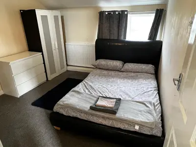 a bedroom with a bed with a black headboard at Preston Central Flats in Preston