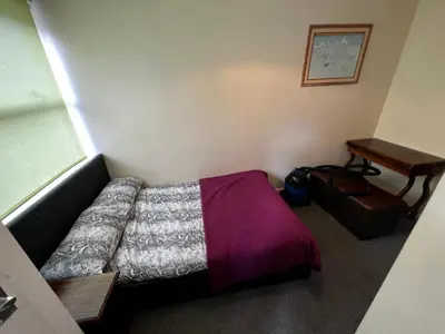 a small bedroom with a bed and a table at Preston Central Flats in Preston