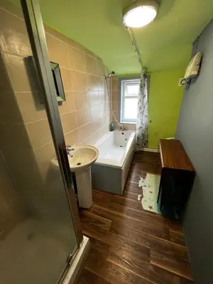a bathroom with a bath tub and a sink at Preston Central Flats in Preston