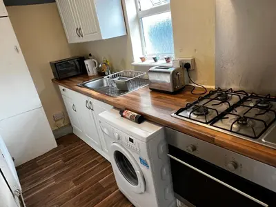 a kitchen with a stove and a washing machine at Preston Central Flats in Preston